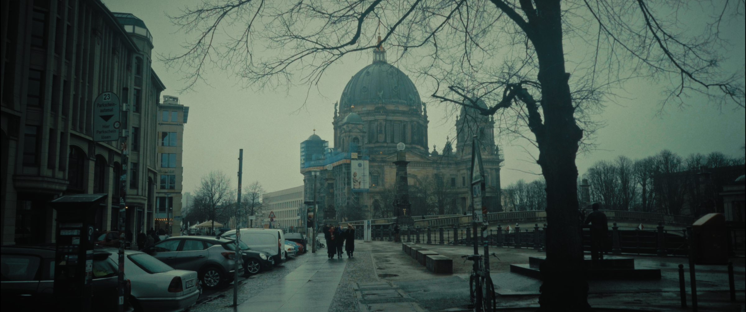 Berliner Dom viewed from a rainy street with pedestrians